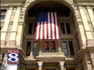 A U.S. flag hangs over the entrance to the Texas Capitol.